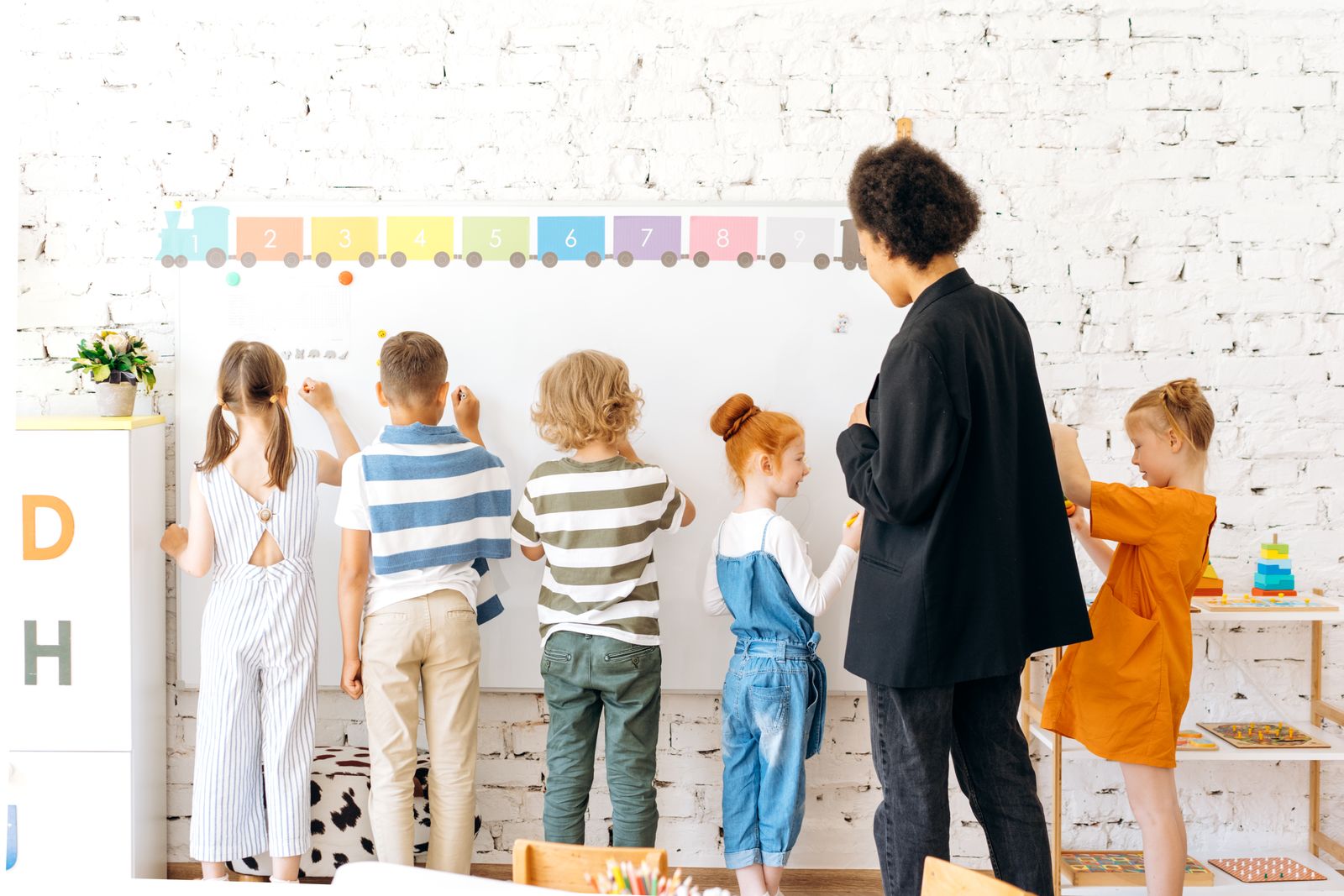 An instructor supporting elementary-aged students during a classroom activity